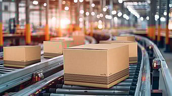 There are some boxes moving along a rail in a factory.